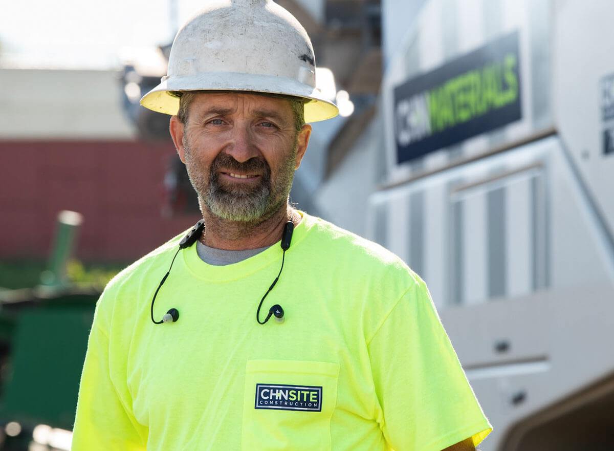 CH+N Materials project manager smiling in front of equipment