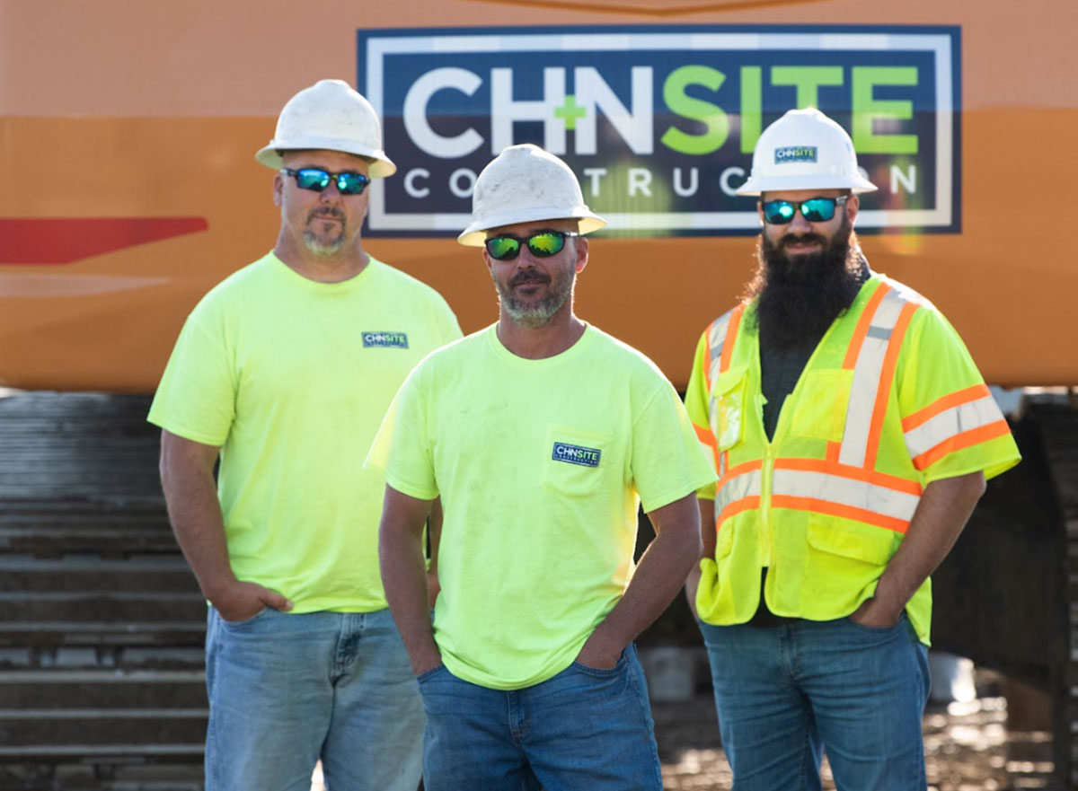 Four CH+N Site team members on a construction site in safety gear